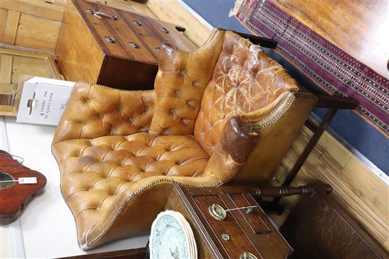 A pair of leather tan wing armchairs